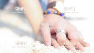 【沖縄】砂浜で手を繋ぐカップル 写真素材